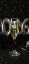 Load image into Gallery viewer, Champagne glass with gold bubbles next to silver '2026' balloons on a black background